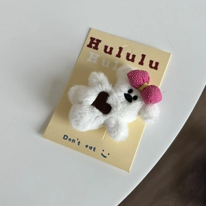 Détail de la pince à cheveux ours en peluche avec nœud rose et broderie cœur sur carte