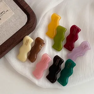 Colorful acetate wavy hair clips in nine candy colors with golden handmade lettering