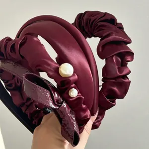 Elegant cherry red satin headband collection featuring pleated designs and pearl accents