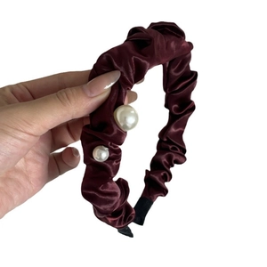 Elegant cherry red satin headband with vintage pleats and pearl accents on white background