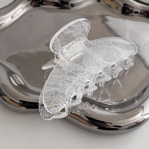 Elegant transparent lace pattern hair claw clip displayed on a modern silver metal tray