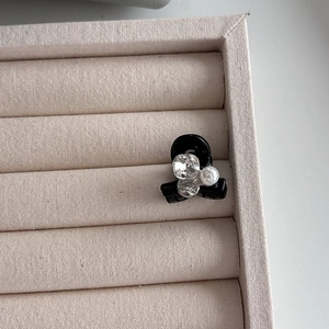 Détail d'une petite pince à cheveux noire avec cristal carré et perle blanche ronde