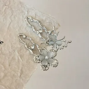 Macro de pinces à cheveux argentées avec papillon, fleur, pierres œil de chat et strass