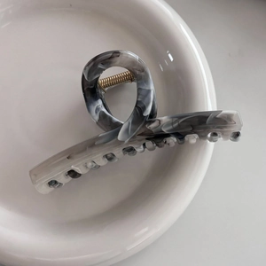 Close-up of gray ink marble acetate hair claw clip showing polished texture and metal spring