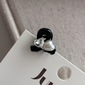 Vue détaillée d'une mini pince à cheveux noire avec cœurs en cristal et perle nacrée