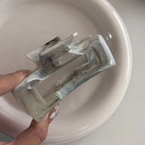 Close-up of marble pattern rectangular hair claw clip with grey ink wash finish