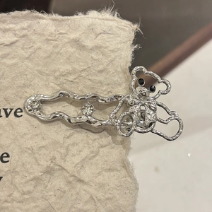 Détail de la pince à cheveux ours Y2K argentée avec strass sur papier artistique