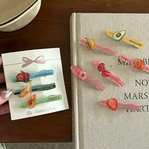 Detailopname van kleurrijke acryl haarspeldjes met fruitmotieven en glitterdetails