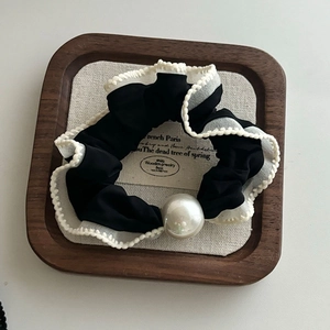 Detail of French vintage mesh hair scrunchie with large white pearl and wavy edges