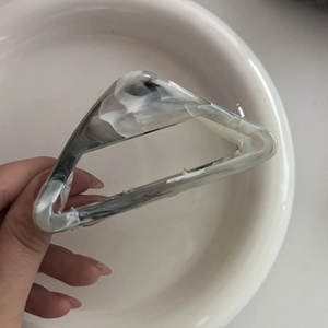 Macro detail of large triangular grey marble hair claw clip with glossy acetate texture