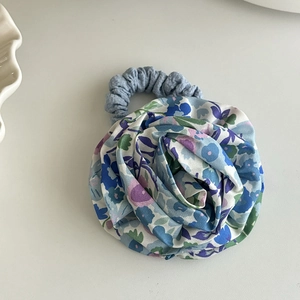 Detail eines geblümten Haargummis mit blauer 3D-Stoffrose für Mädchen und Kinder
