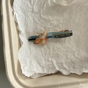 Detailopname van de creatieve bananenvormige haarklem met gouden snavelclip metaal