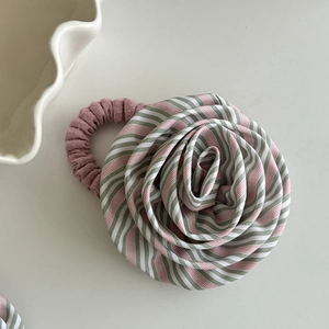 Detailansicht eines handgefertigten Rosen-Haargummis aus gestreiftem Stoff in Rosa und Grün