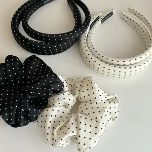 Detailed view of handmade black and white polka dot satin scrunchies and headbands