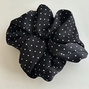 Classic black and white polka dot scrunchie with smooth satin-like textured fabric