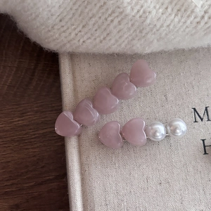 Detalle del set de pinzas para el cabello con corazones de resina rosa y perlas finas