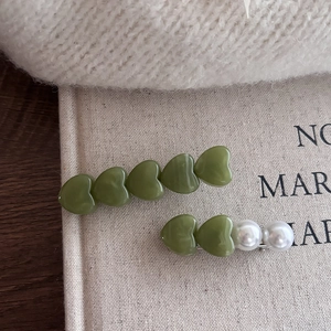 Set de dos clips para el pelo con corazones verdes y perlas sobre base de metal plateado