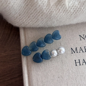 Elegante conjunto de pinzas para el cabello de corazón azul con perlas y fondo cálido