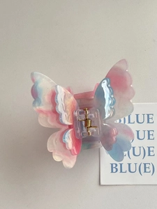 Detail view of butterfly hair claw with pink and blue gradient acetic acid texture