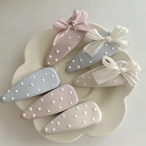 Set di 6 fermagli per capelli a pois blu e rosa con fiocchi in tulle in un piatto ceramico