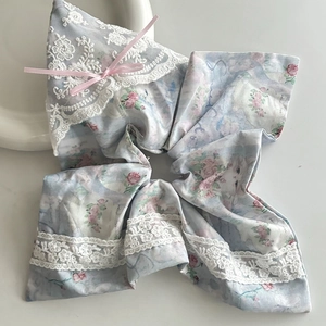 Dettaglio scrunchie floreale con rose rosa, motivo gatto, pizzo bianco e fiocco di nastro