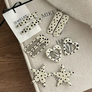 Polka dot hair clip set with wave, heart, and star designs on a vintage background