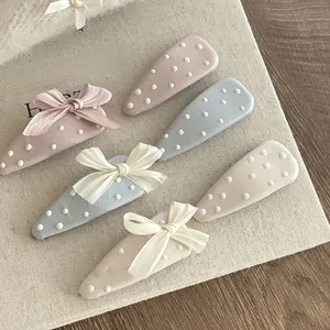 Dettaglio di un set di fermagli per capelli blu e lavanda con pois e fiocchi eleganti