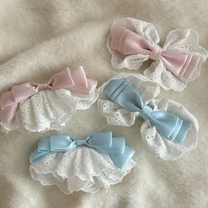 Détail de pinces à cheveux nœuds en satin rose et bleu avec dentelle sur tissu en peluche