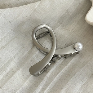 Pince à cheveux minimaliste en métal argenté avec design croisé et accent perle blanche