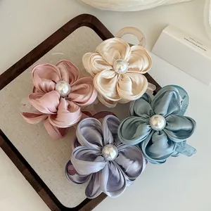 Detaillierte Makroansicht eleganter Satin-Blumen-Haarklammern mit Perlenmitte in vier Farben