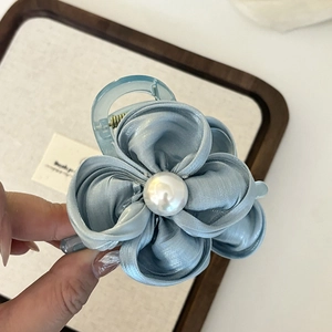 Nahaufnahme einer hellblauen Blumen-Haarklammer mit Satinblüten und großer Perle