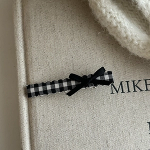 Plaid checkered hair clip with black ribbon bow for women in soft warm lighting