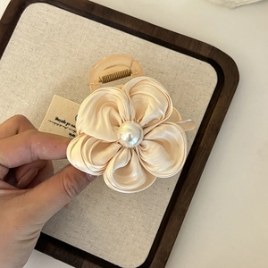 Detailaufnahme der eleganten cremefarbenen Satin-Blumen-Haarklammer mit Perle