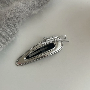 Detail of silver faux leather BB hair clip with bowknot and neat stitching edges