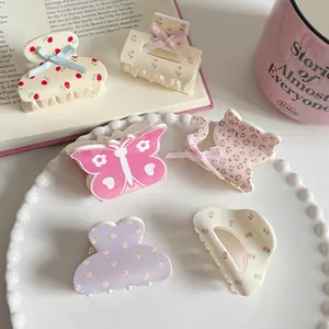 Floral and bow hair claw clip set of six with cherry and leopard patterns on a porcelain tray