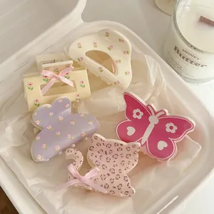 Detailed set of floral hair claws with bows and heart patterns on white tissue paper