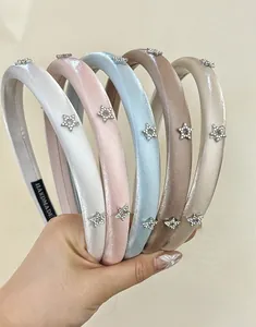 Detail of satin sponge headbands with rhinestone star accents in multiple soft pastel colors