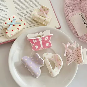 Close-up of pink floral and leopard print hair claws arranged on a ceramic tray