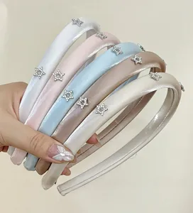 Detail showing padded satin headbands with sparkling rhinestone star decorations in five pastel colors