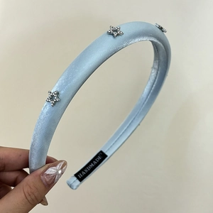 Light blue padded satin headband featuring three silver rhinestone stars for women