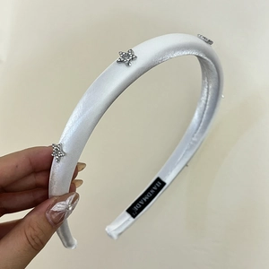 White satin padded headband featuring sparkling star rhinestones and handmade quality finish