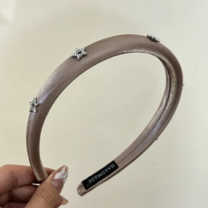 Detail of handmade padded satin headband with silver rhinestone star embellishments