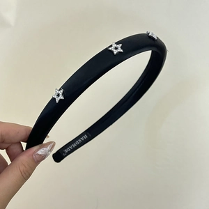 Detail of black satin headband featuring three silver stars with sparkling rhinestones