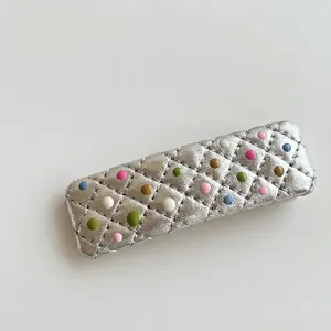 Silver quilted rectangular hair clip with colorful polka dots and metallic finish