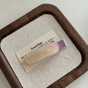 Dettaglio molletta in resina marmorizzata crema con clip in metallo lilla