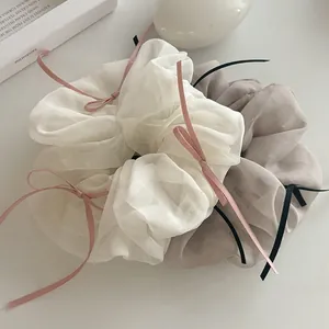 Détail de chouchous en organza blanc et gris avec nœuds en ruban délicats, lot de deux