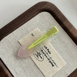 Detailed close-up of a sweet light green hair clip with a gradient lavender acetate finish