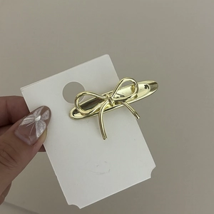 Barrette à cheveux minimaliste en métal doré avec nœud papillon sur carte support