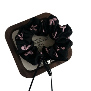 Black satin hair scrunchie with pink bow prints and a silver heart pendant accessory