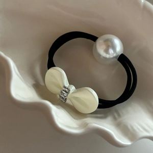 Elegant black elastic hair tie with large pearl and rhinestone bow on shell plate